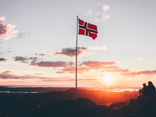 Norwegische Flagge, Sonnenuntergang im Hintergrund