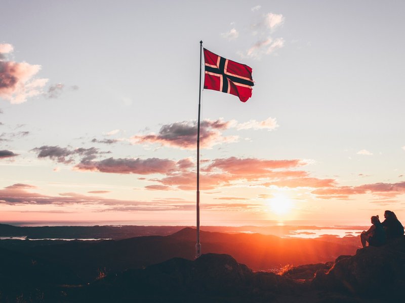 Norwegische Flagge, Sonnenuntergang im Hintergrund