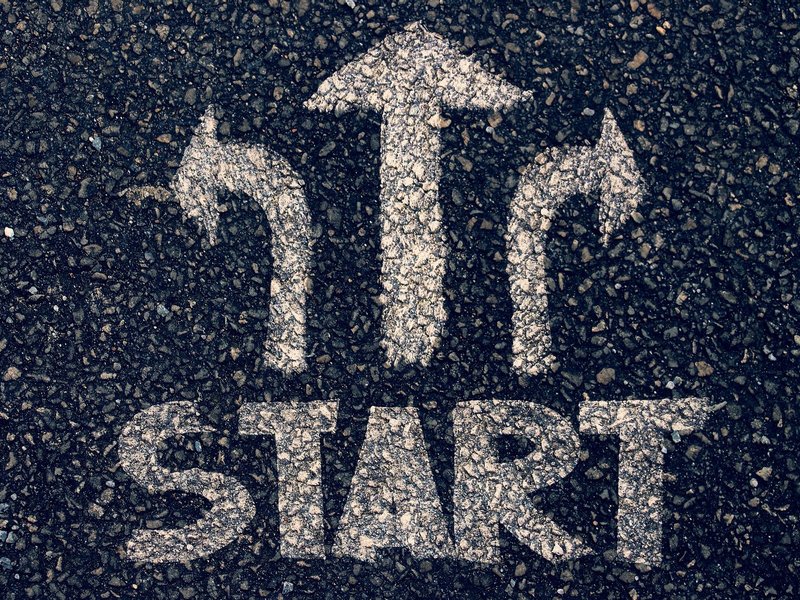 Schriftzug "Start" mit drei Pfeilen, die in unterschiedliche Richtungen weisen